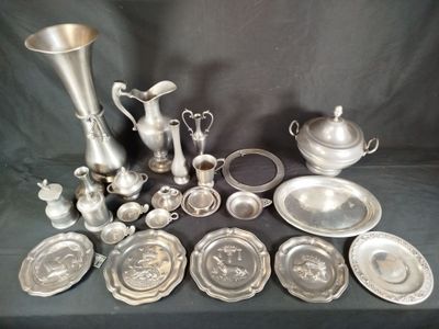 a lot of silver plates and silver vases on a table