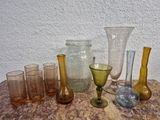 de nombreux vases et verres en verre de différentes couleurs posés sur une table