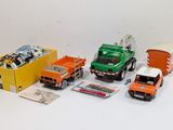 several toy trucks are lined up in a row on a white surface