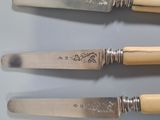 three forks and a knife on a table