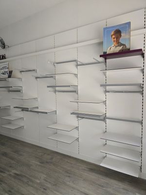 une photo d'une pièce avec des étagères et un tableau accroché au mur