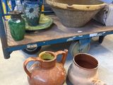 de nombreux vases et bols posés sur une étagère dans une pièce