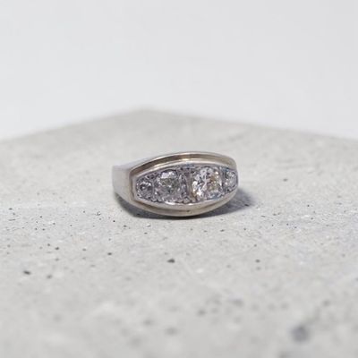 une photo d'une bague en diamant posée sur une surface en béton