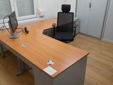 a desk with a computer and a chair in the room