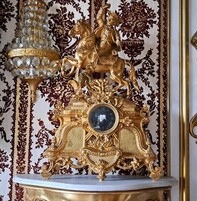 GRANDE PENDULE en régule doré à décor d'un cavalier sur sa m…