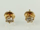 une paire de boucles d'oreilles en diamant sur une surface blanche