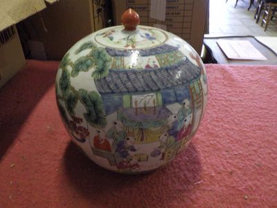 a vase with a lid on a table in a room