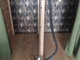 a steam iron sitting on a wooden floor in front of a curtain