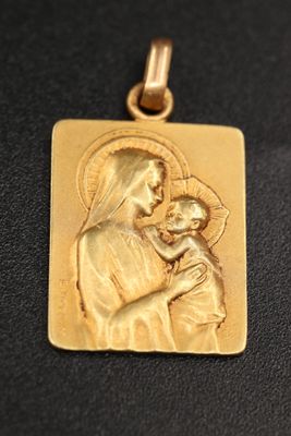a gold plated pendant with a picture of the virgin and child
