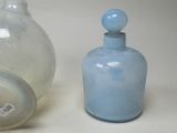two glass bottles sitting next to each other on a table