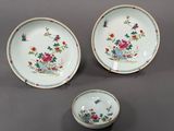 trois assiettes en porcelaine et un bol posés sur une table