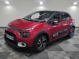 a red citrole is parked in a room with a checkered floor