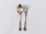 two silver spoons and a fork on a white surface