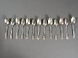 six silver spoons lined up in a row on a gray surface
