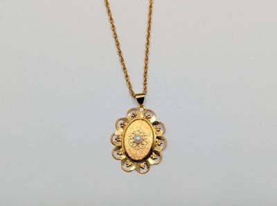 a gold necklace with a coin on a chain