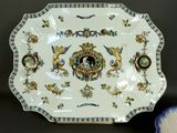 a plate with a decorative design on it next to a bowl