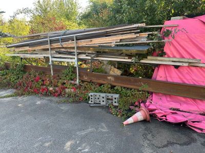 a pink tarp covering a pile of wood in a parking lot