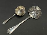 two silver spoons and a spoon on a black surface