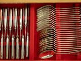 many forks and spoons in a red box