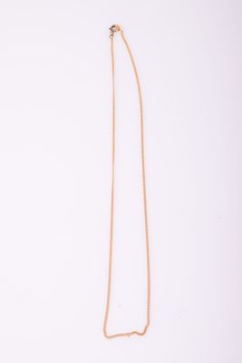 un collier en or avec une longue chaîne sur fond blanc