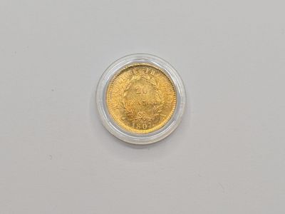 un gros plan d'une pièce de monnaie dans un récipient en plastique posé sur une surface blanche