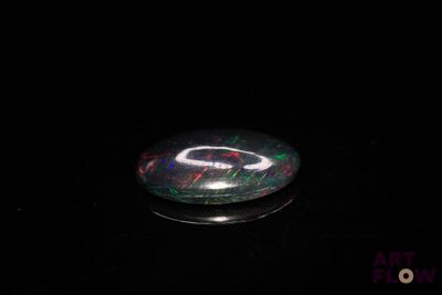 a picture of a black and green glass object on a black surface