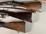 several old guns are hanging on a wall in a room