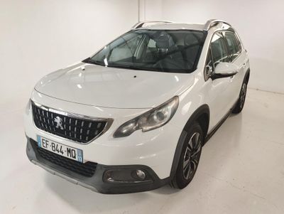 La voiture blanche est garée dans une pièce blanche au sol blanc.