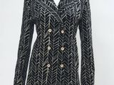 un mannequin portant une veste noire et blanche à boutons dorés