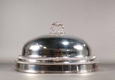 un plat en argent avec un couvercle en argent posé sur une table