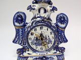 a blue and white clock sitting on top of a table