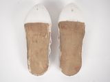 pair of white slippers on a white surface with a white background