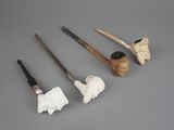 four different types of pipe smokings are lined up on a gray surface