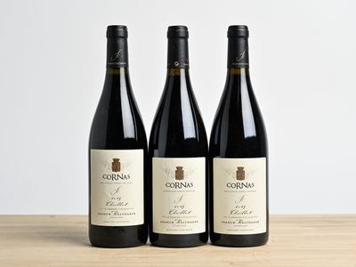 three bottles of wine sitting on top of a wooden table