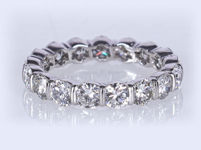 un gros plan d'une bague éternité en diamants sur fond blanc