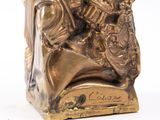 an antique bronze figurine of a man and woman on a horse