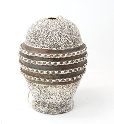 a silver vase with a chain around it on a white surface