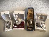 trois objets plaqués argent se trouvent dans une boîte posée sur une table
