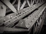 black and white photograph of a metal bridge with rivets and bolts