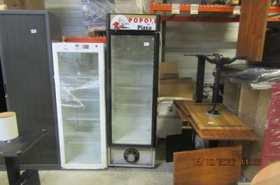 a refrigerator that is sitting next to a table in a room