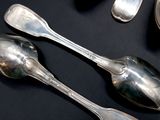 several silver spoons and spoon spoons on a black surface