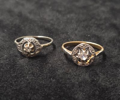 deux bagues en or et en argent serties de diamants sur un fond noir