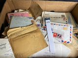 a cardboard box full of letters and envelopes on the floor