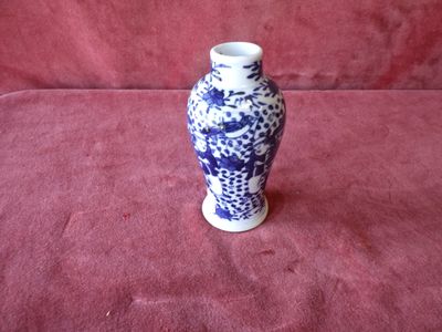 a blue and white vase sitting on a red cloth