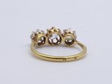 a yellow gold ring with three diamonds on top of it