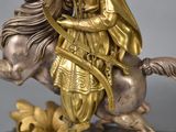 a statue of a man riding a horse with a bow