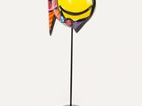 a close up of a colorful fish sculpture on a black stand