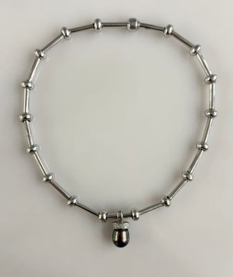 un gros plan sur un bracelet en argent orné d'une clochette