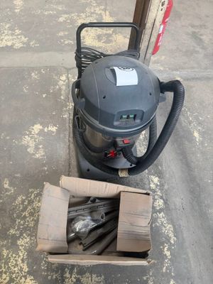 a box of tools sitting on the sidewalk next to a vacuum