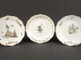 trois assiettes ornées d'oiseaux et de fleurs, posées sur une table